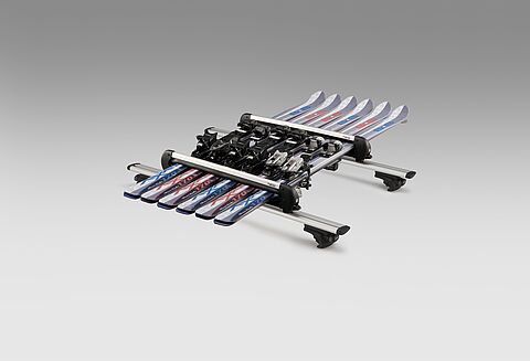 Porte-skis avec 3 paires de skis montés sur un porte-bagages de toit sur fond gris clair